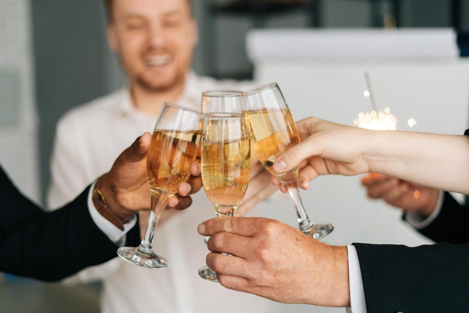 Co-workers clinking Champagne glasses together at a formal business event
